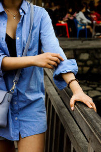 Midsection of woman standing on footbridge