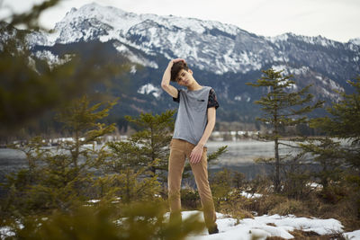 Rear view of woman standing in lake during winter