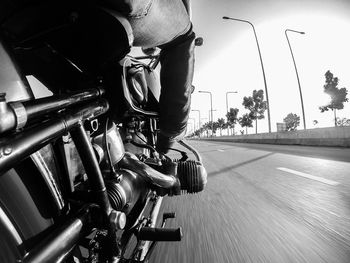 Low section of man riding bicycle on road