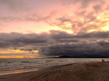 Scenic view of beach against dramatic sky