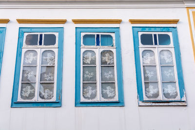 Low angle view of blue glass window on building