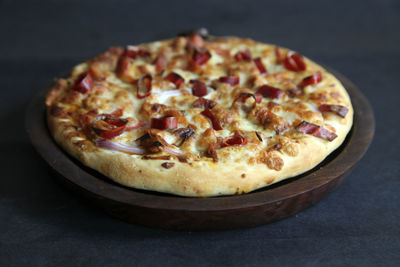 Close-up of pizza on table against black background