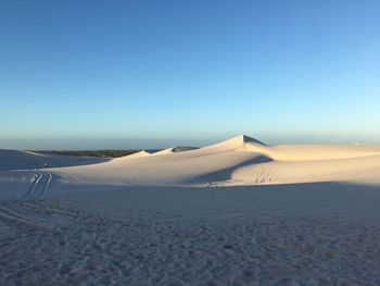 Scenic view of desert against clear blue sky