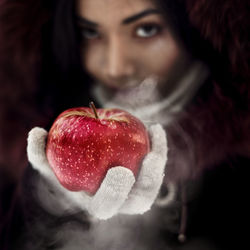 Close-up portrait of woman holding apple