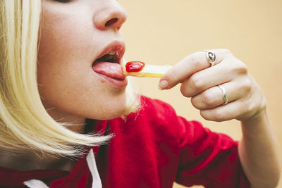 Woman eating french fries with ketchup