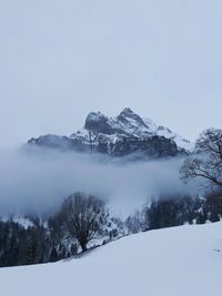 Scenic view of snow covered mountains against sky