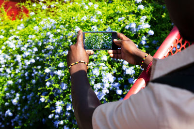 Midsection of woman photographing with mobile phone