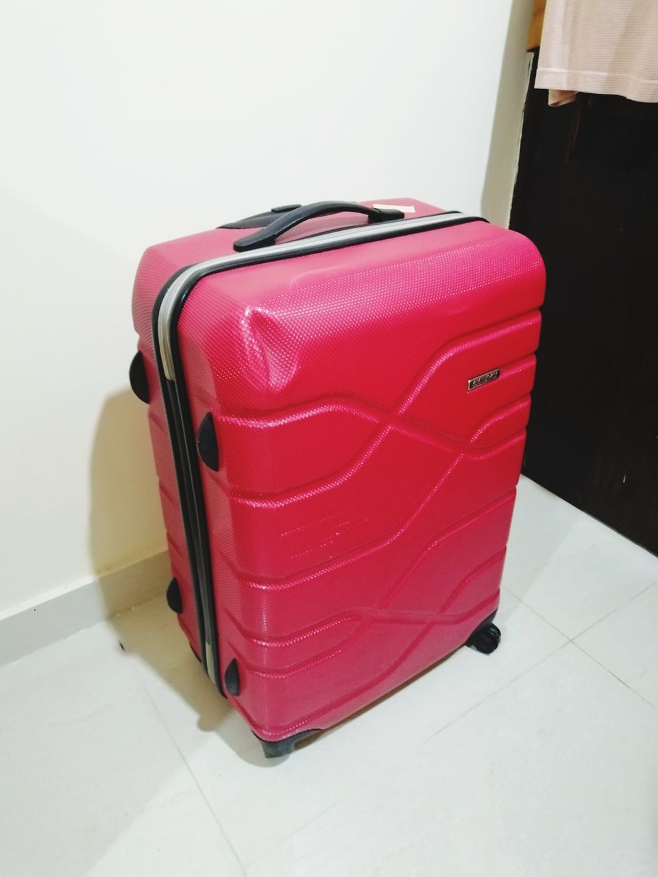 suitcase, luggage, travel, hand luggage, indoors, red, bag, journey, trip, vacation, pink, luggage and bags, holiday, flooring, tiled floor, airport, no people, business travel, tile, tourism, home interior, magenta, furniture