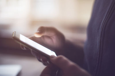 Midsection of man using mobile phone