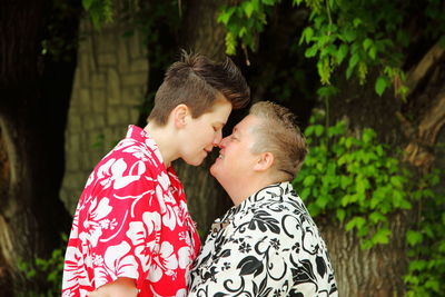 Side view of lesbian couple rubbing noses in lawn