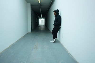 Side view of man standing in corridor