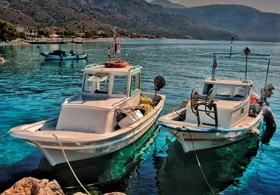 Boats moored in sea against sky