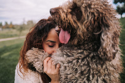 Close-up of woman playing with dog at park