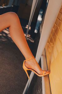 Low section of woman with high heels on floor