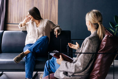 A crying woman in an emotional crisis at a consultation with a psychotherapist.