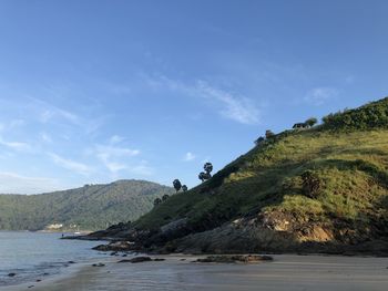 Scenic view of sea and mountains against blue sky