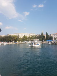 Boats in sea against buildings in city