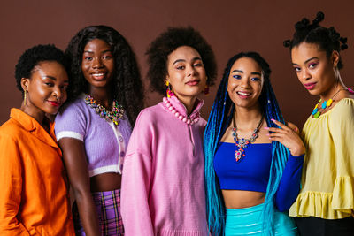 Portrait of smiling friends against colored background