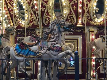 Statue of illuminated carousel at amusement park