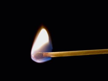 Close-up of illuminated lamp over black background