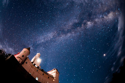 Low angle view of building against star field at night