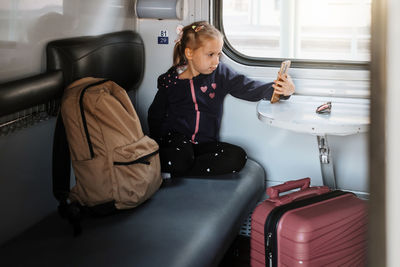 Side view of young woman sitting in train