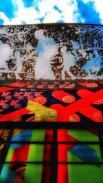 Close-up of multi colored umbrellas against sky