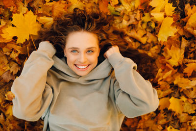 Portrait of young woman standing amidst yellow flowers