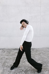 Portrait of young man standing against wall