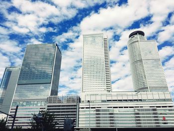 Low angle view of buildings against cloudy sky