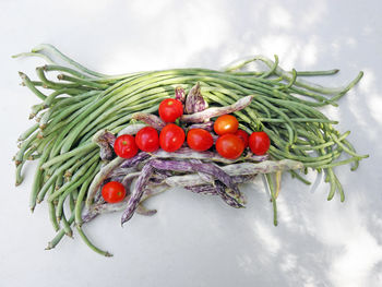 Chinese long beans and dragon tongue bush beans with cherry tomatoes on table