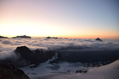 Scenic view of snowcapped mountains against sky during sunset