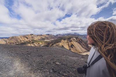 Woman looking away at top of mountain in landmannalaugar, highlands