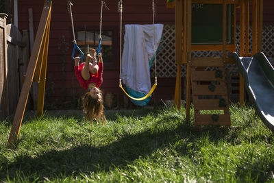 Playful girl hanging upside down at playground