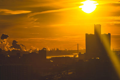 Silhouette buildings against orange sky during sunset