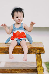 Portrait of boy sitting on bench