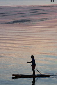 Silhouette man standing on sea shore