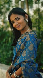 Portrait of smiling young woman sitting outdoors