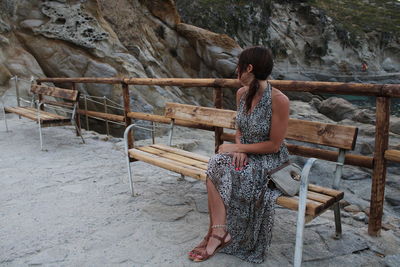 Full length of woman sitting on rock