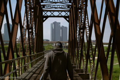Man standing on bridge in city
