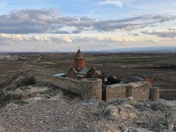 Old ruins on landscape against sky