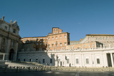 Low angle view of buildings against clear blue sky