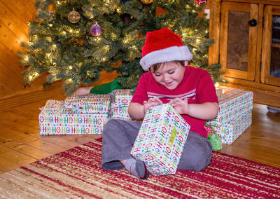 Excited little boy is opening a christmas present