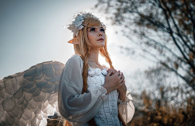 Close-up of woman standing against sky during winter