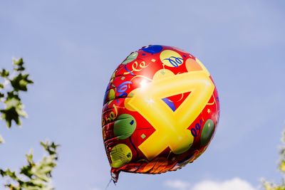 Low angle view of balloons against blue sky