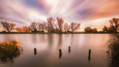 Scenic view of lake against sky at sunset