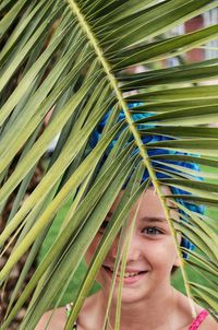 Portrait of a smiling woman with palm leaves