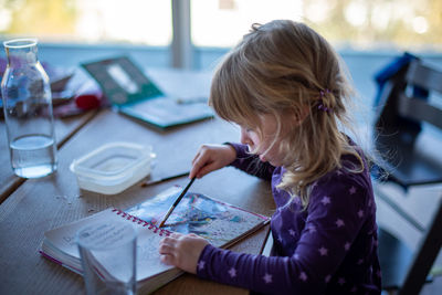 High angle view of girl drawing on table