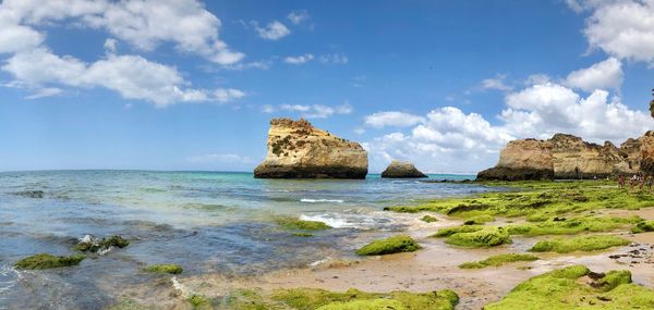 Panoramic view of rocks on beach against sky