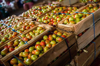 High angle view of tomatoes in baskets for sale at market stall